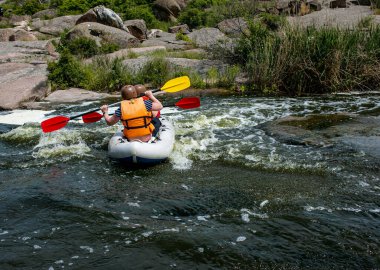 Aktif eğlence konsepti. Bir grup genç nehrin aşağısında rafting yapıyor..
