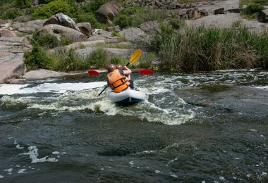 Aktif eğlence konsepti. Bir grup genç nehrin aşağısında rafting yapıyor..
