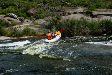 Aktif eğlence konsepti. Bir grup genç nehrin aşağısında rafting yapıyor..