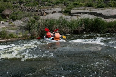 Aktif eğlence konsepti. Bir grup genç nehrin aşağısında rafting yapıyor..