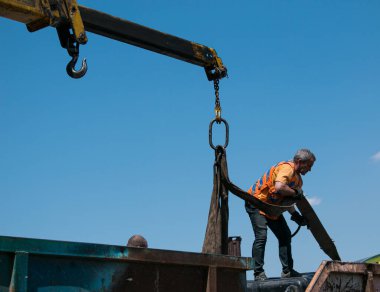 Dnepropetrovsk, Ukrayna - 05.28.2021: Çöp konteynerlerini vinç kullanarak bir kamyona yüklemek. Slinger çalışıyor..