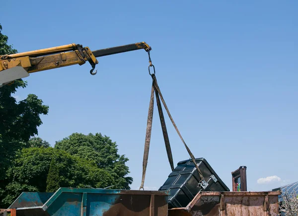 Çöp konteynırlarını vinç kullanarak bir kamyona yüklüyorlar. Slinger çalışıyor..