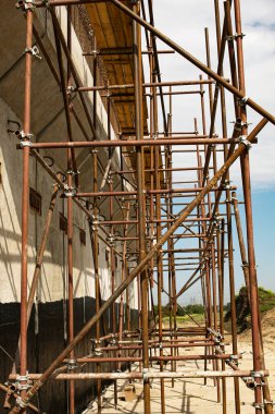 İskele kulesi ve binası olan bir inşaat alanı. İnşaat fabrikası iskelesi..