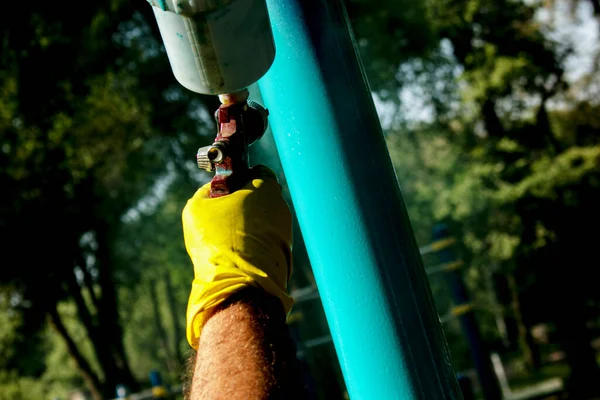 市政府的工作人员在公园的操场上油漆管道 用气球喷漆 — 图库照片