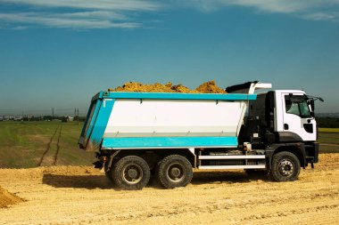 Çöp kamyonu yeni bir otoyol inşaatı için kil toprağı boşaltıyor. Yeni bir yolun temelini attığı için Clay..