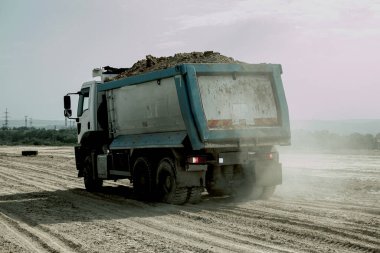 Çöp kamyonu yeni bir otoyol inşaatı için kil toprağı boşaltıyor. Yeni bir yolun temelini attığı için Clay..