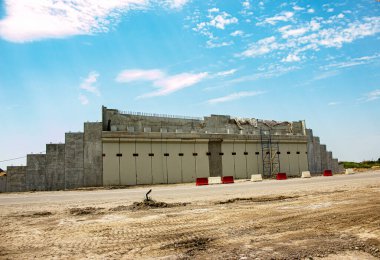 Otobanda inşaat halindeki yol üst geçidi. Bulutlu gökyüzüne karşı viyadük desteği.