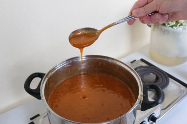 Evde kayısı reçeli üretme süreci. Kayısı reçelli bir tencere..