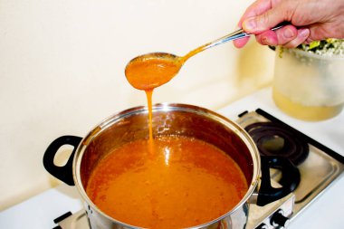 Evde kayısı reçeli üretme süreci. Kayısı reçelli bir tencere..