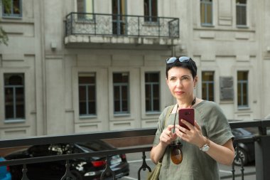 Şehirde telefonu olan çekici, orta yaşlı bir kadın. Kadın telefonda duygusal olarak konuşuyor..