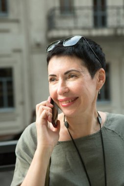 Şehirde telefonu olan çekici, orta yaşlı bir kadın. Kadın telefonda duygusal olarak konuşuyor..