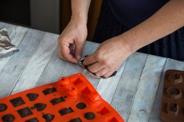 Adım adım, evdeki konyakta siyah çikolata ve kirazdan çikolata yapma süreci. Her bir şeker silikon kalıptan çıkartılır ve folyoya sarılır. Mutfak blogu kavramı.