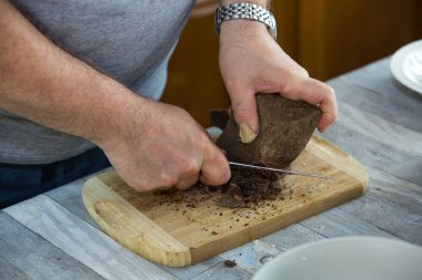 Adım adım, evdeki konyakta siyah çikolata ve kirazdan çikolata yapma süreci. Kakao yağı ve kakao likörü tartılır ve öğütülür. Mutfak blogu kavramı.