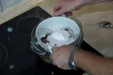 Adım adım, evdeki konyakta siyah çikolata ve kirazdan çikolata yapma süreci. Su banyosunda çikolatanın bileşenlerini eritme süreci. Mutfak blogu kavramı.