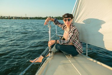 Lüks bir yat tatili. Tekne güvertesinde güneş gözlüklü mutlu orta yaşlı kadın nehirde yüzüyor..