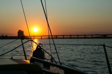 Dinyeper Nehri manzarası ve yatın yan tarafındaki köprü. Güneşin batışındaki şehir manzarası.