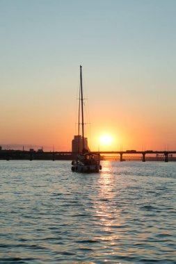 Dinyeper Nehri manzarası ve yatın yan tarafındaki köprü. Güneşin batışındaki şehir manzarası.