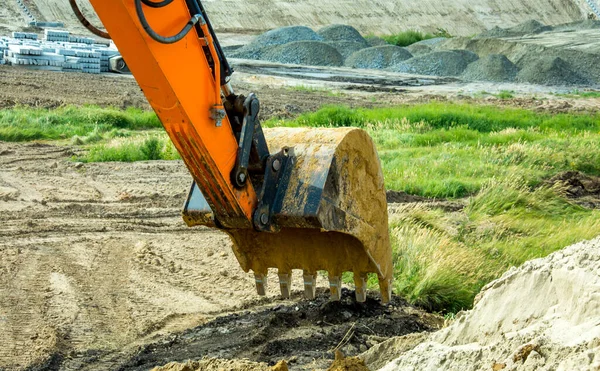 Closeup bucket of backhoe digging the soil at construction site. Crawler excavator digging on demolition site. Excavating machine. Earth moving equipment. Excavation vehicle. Construction business.
