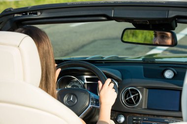 Dnepropetrovsk, Ukrayna - 08.24.2021: Mercedes Benz araba lüks ulaşım yaşam tarzı kullanan kadınlara yakın çekim. Mercedes Benz SL550 üstü açık araba yolda.