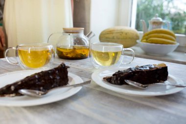 Öğleden sonra çayı. Naneli ve limonlu çaydanlık demlenmiş çay, fincanlar ve ev yapımı tatlılar. Çay için masa hazır. Tatlıyla birlikte iç..