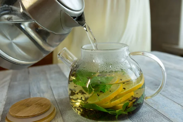 Una Mujer Vierte Agua Caliente Una Tetera Con Menta Limón — Foto de Stock