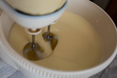 Pasta yapma süreci. Tüm malzemeler karıştırma kabına eklenir. Hamur çırpmayla yoğurulur. Adım adım çikolatalı pasta tarifi. Seriler. Pişirme kavramı.