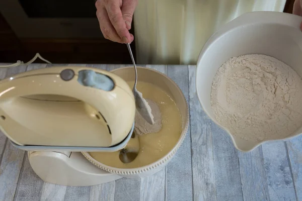 Cake making process. Female hands add flour to the mixer bowl for making dough. Step by step recipe for chocolate cake. Series. Baking concept.