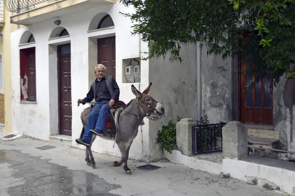 Man on donkey in the picturesque town of Plomari — Stock Photo, Image