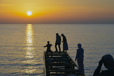 iskelede'nde Günbatımı oynayan gençler