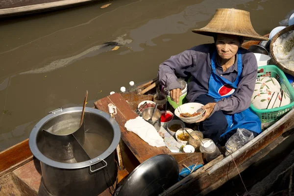 Femme cuisine en vendant soupe de nouilles au marché flottant Bangkok — Photo