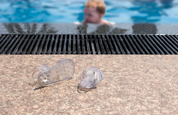 Chanclas de bebé en el suelo de la piscina —  Fotos de Stock