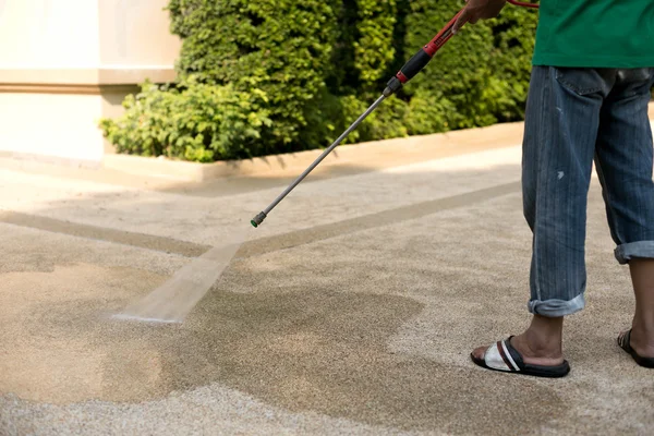 Arbeiter reinigen verschmutzten Boden mit Hochdruck-Wasserstrahl — Stockfoto