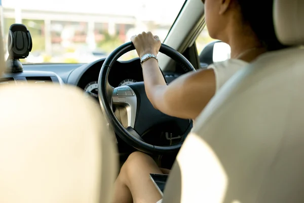 Vrouw met mobiele telefoon op haar schoot tijdens het rijden — Stockfoto