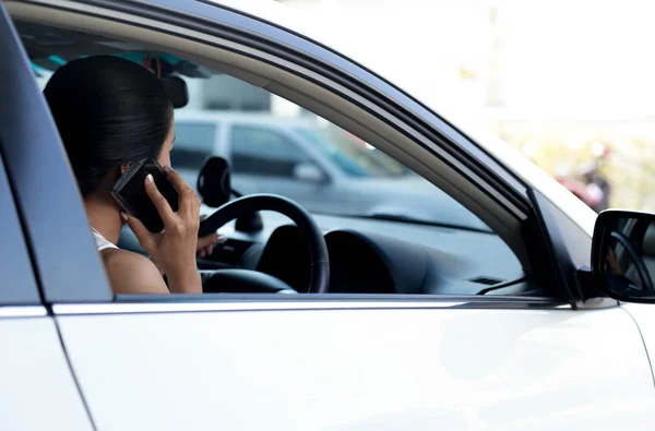 Mujer usando el teléfono celular mientras conduce el coche —  Fotos de Stock