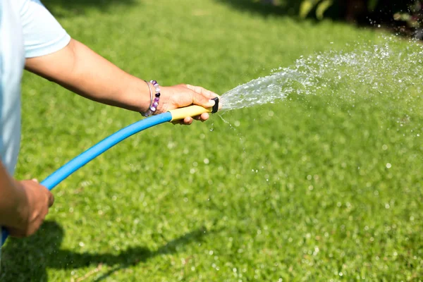 Gärtner gießt Garten aus Schlauch — Stockfoto