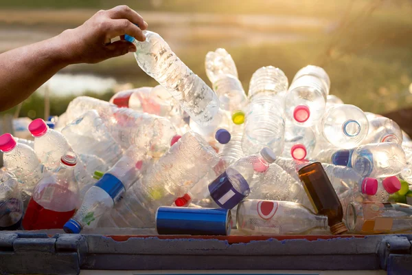 Hand met recyclebaar plastic fles in vuilnisbak — Stockfoto