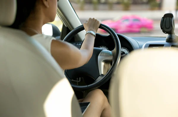 Vrouw met mobiele telefoon op haar schoot tijdens het rijden — Stockfoto