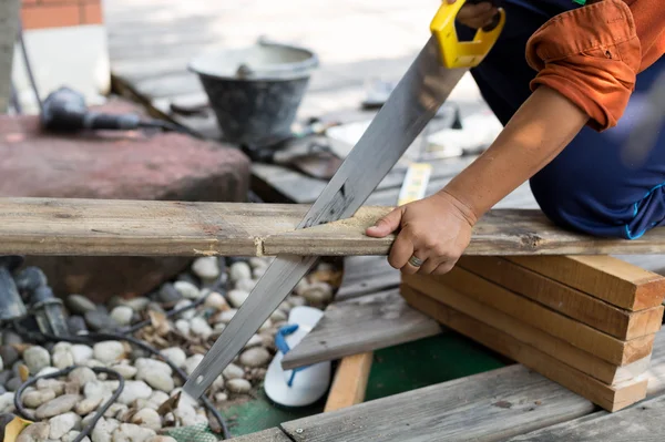Muž, oprava krytiny pilou dřevo dřevo ruční pilou — Stock fotografie