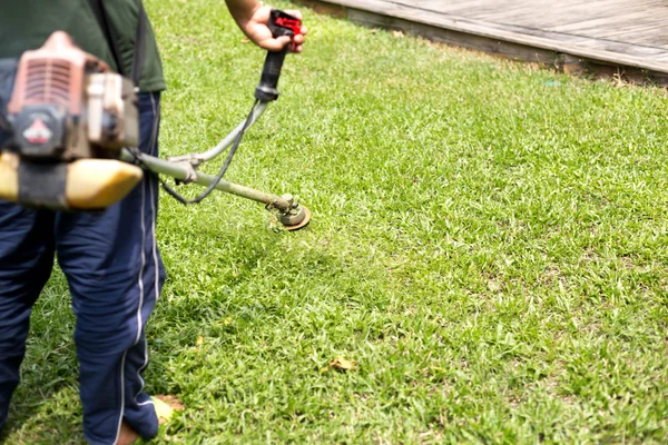 Jardineiro cortando a grama — Fotografia de Stock