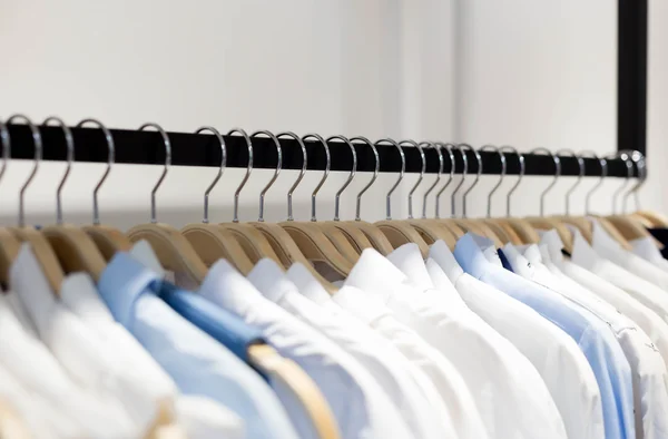 Одежда висит на полке в магазине дизайнерской одежды — стоковое фото