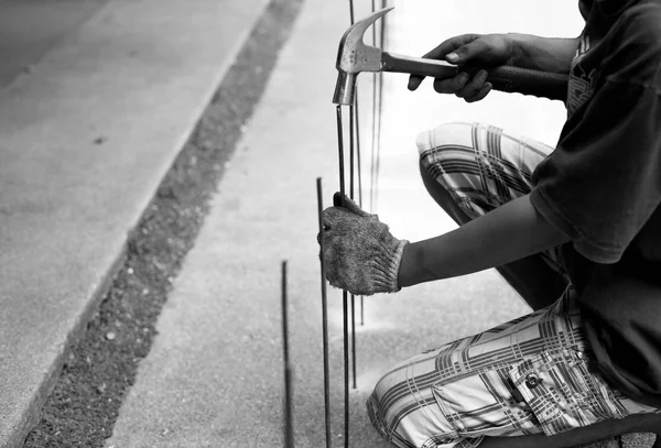 Asian worker with a hammer and steel rod in black and white — Stock Photo, Image