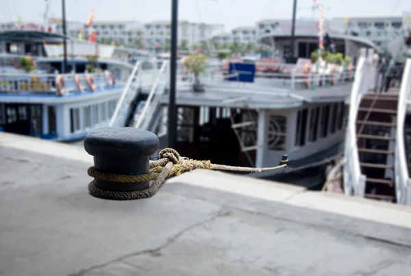 Ελλιμενισμού σχοινί με κόμπους ένα δεμένο γύρω από μια σφήνα με τουριστικό σκάφος — Φωτογραφία Αρχείου