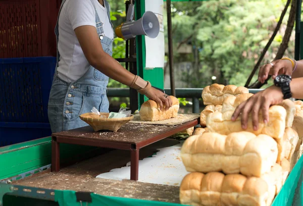 Woman slicing cutting soft bread for feeding fish — Stock Photo, Image