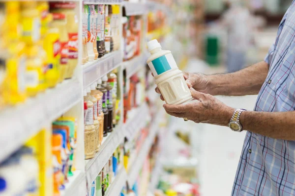 Senior man reading food products at the supermarket