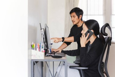 Asyalı çift evde bilgisayarla çalışıyor..