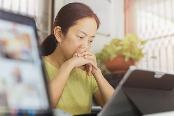 Thoughtful woman looking at laptop with hand under her chin. — Stock Photo, Image