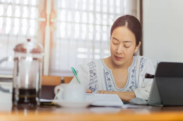 在笔记本电脑上工作并在家里记录工作的女商人. — 图库照片