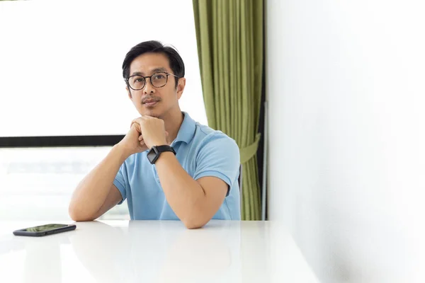 Retrato de hombre asiático con anteojos sentados en el escritorio y mirando a la cámara. — Foto de Stock