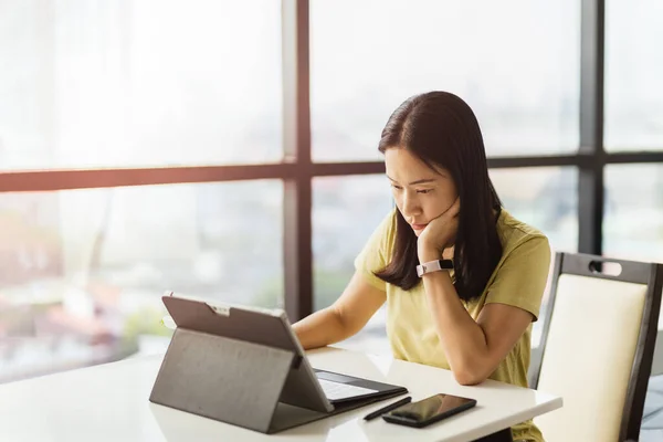 Thoughtful woman working on tablet computer at home. — Stock Photo, Image