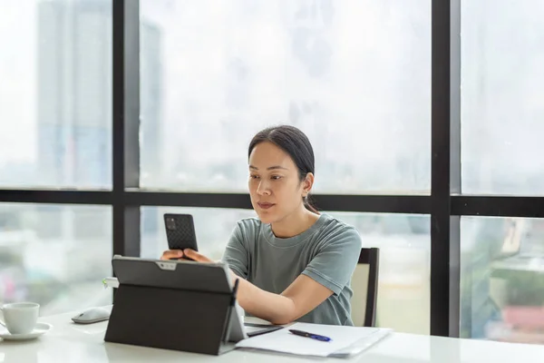 Beautiful woman video call on cell phone while during work on laptop. — Stock Photo, Image